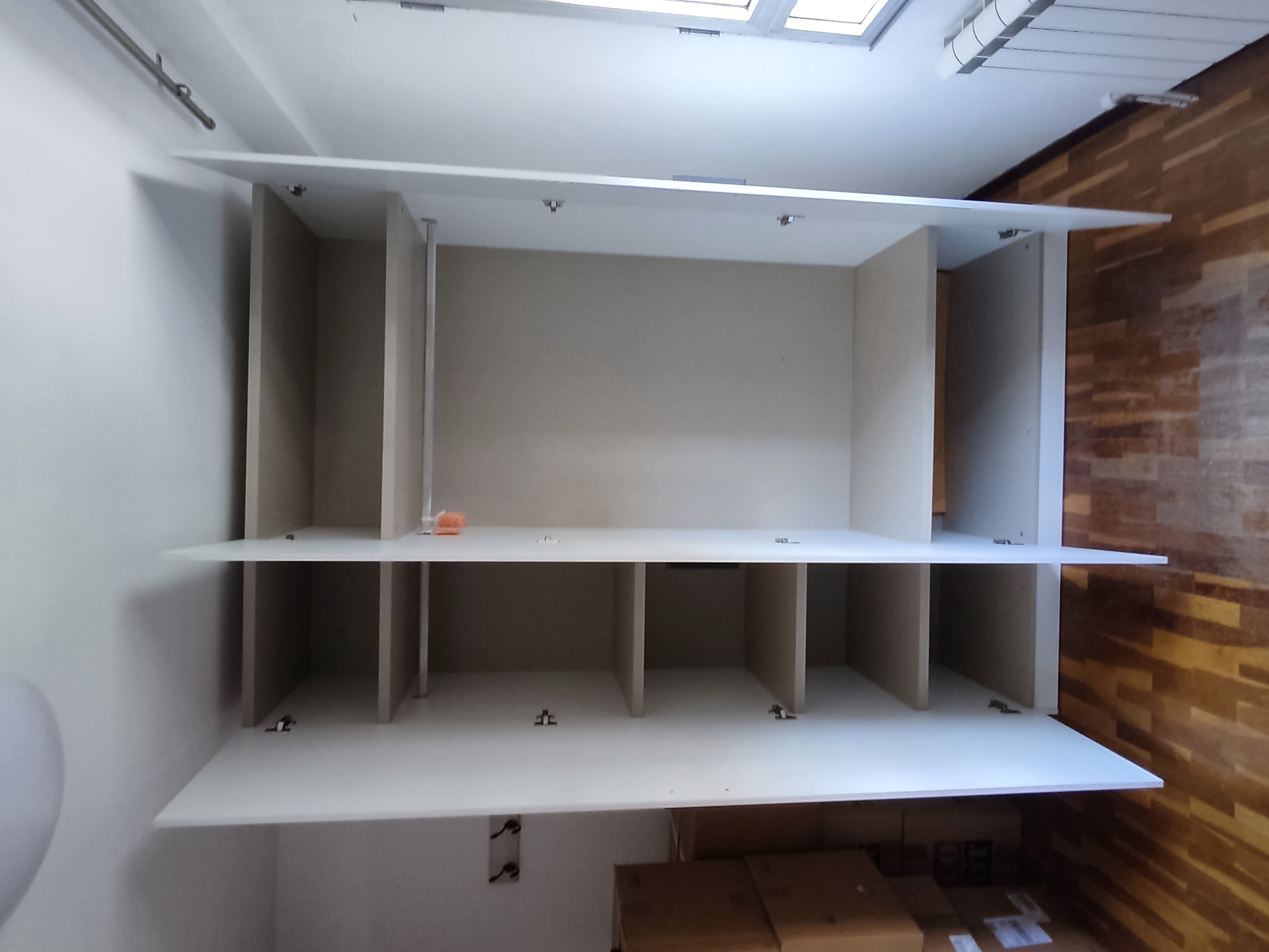 Armari blanc buit obert amb prestatges i divisors muntat per Mudances Sabaté