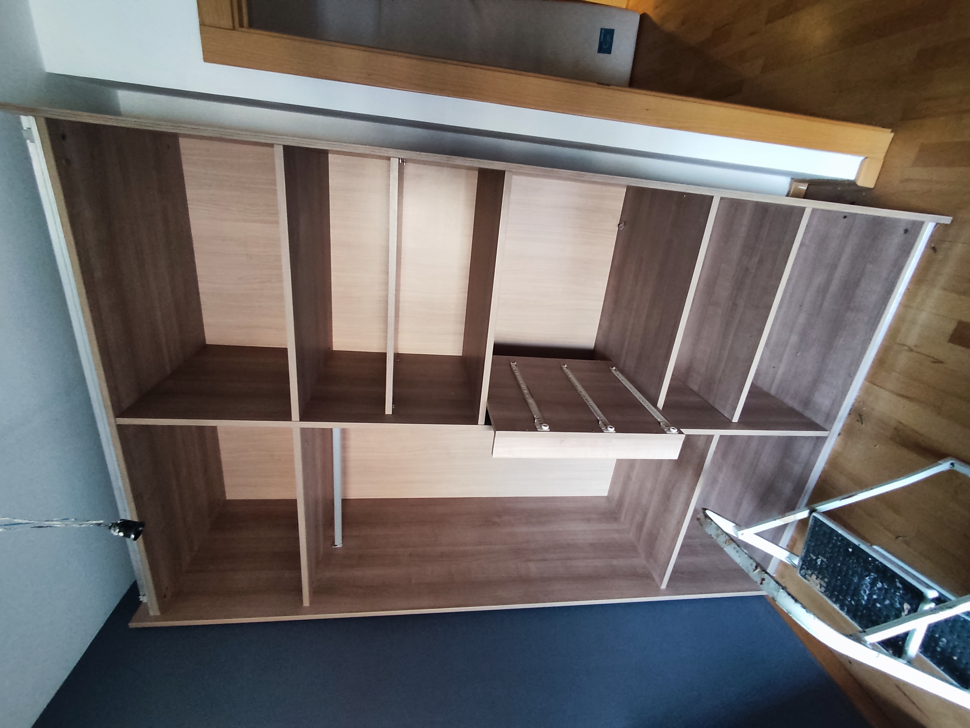 Armari amb portes corredisses de fusta clara obert muntat per Mudances Sabaté