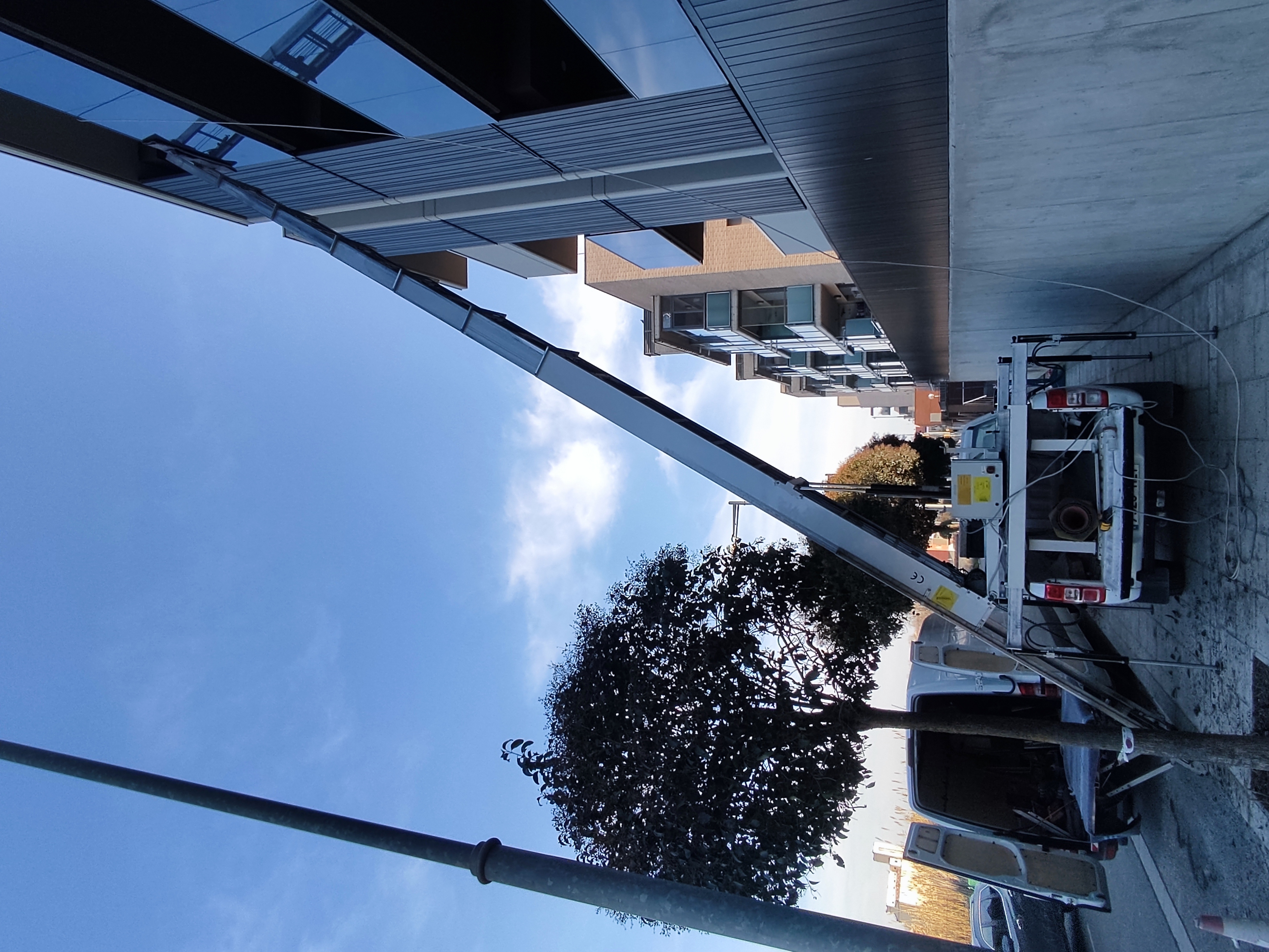 Camió grua de Mudances Sabaté davant edifici modern de formigó