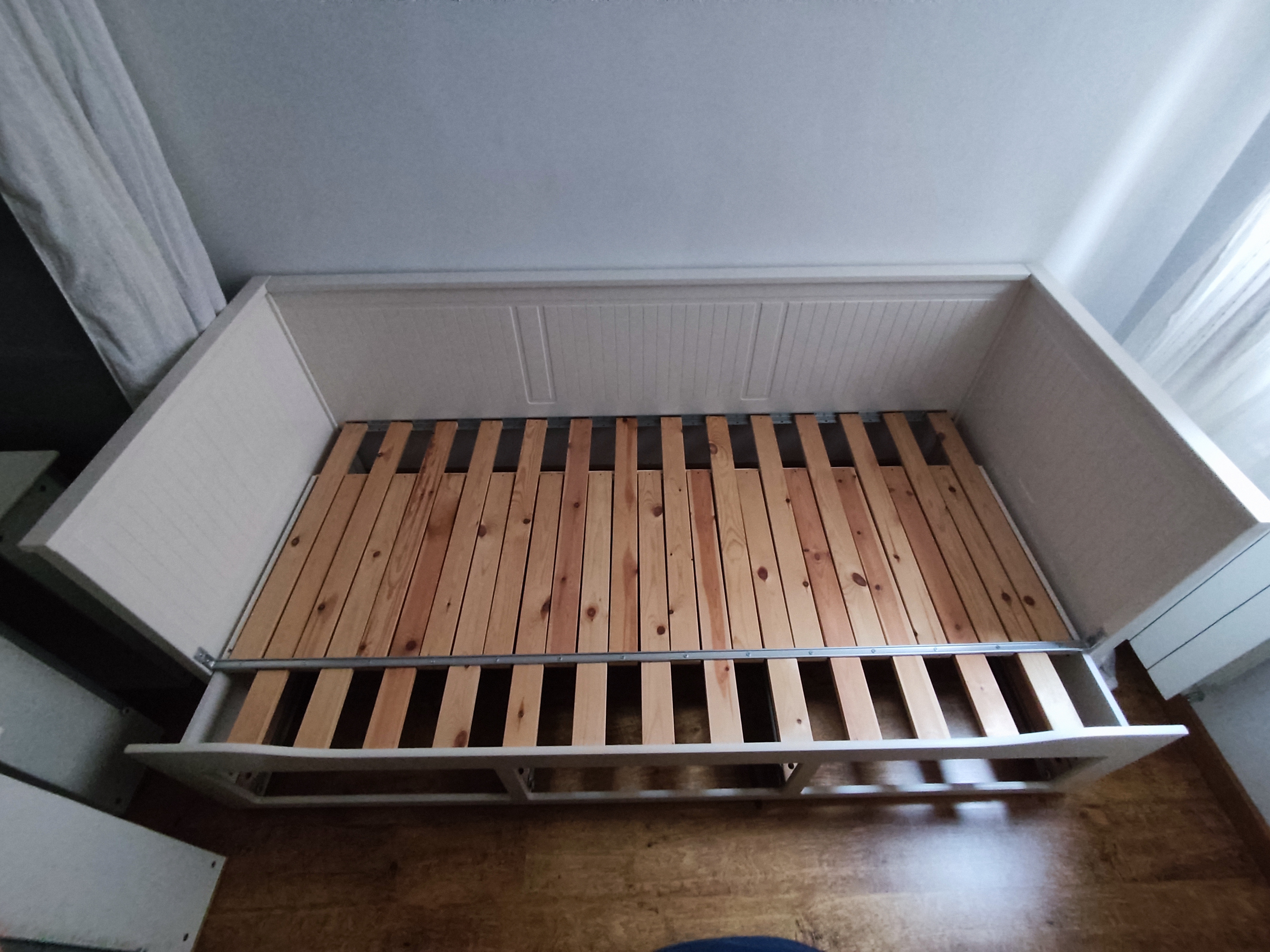 Llit blanc amb somier de llistons muntat a habitació