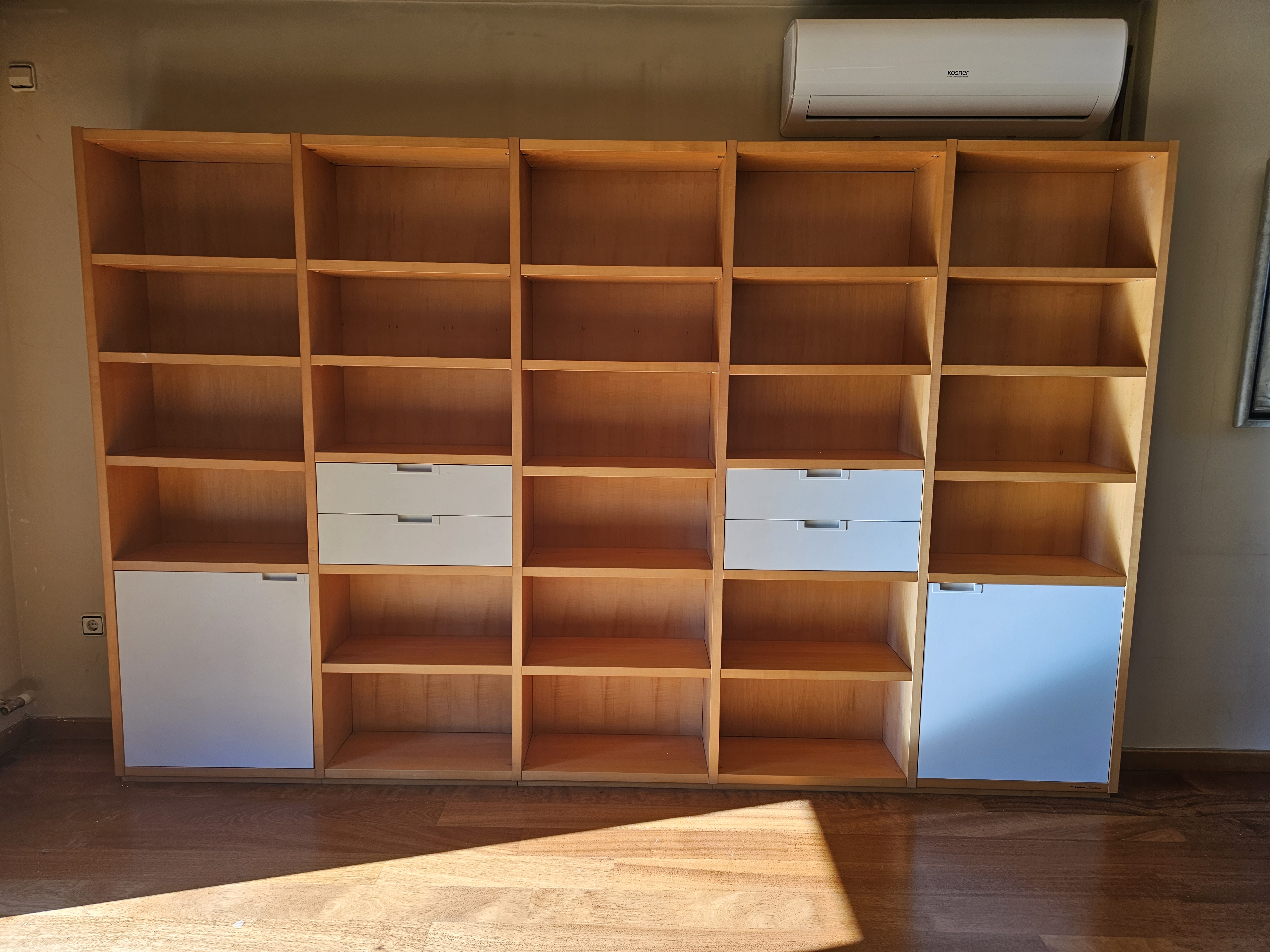 Prestatgeria gran de fusta clara amb calaixos blancs muntada per Mudances Sabaté